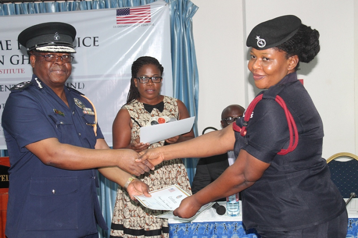 COP Mr James Oppong Boanu (left), Director General in-charge of Administration, Ghana Police Headquarters presenting a certificate to Sergeant Eunice Naterkwor Okai (right), during the closing ceremony